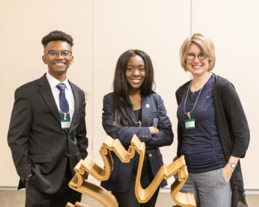 Two students (Jarrett Thomas and Jai Huntley) stand with their professor (Laura Battaglia) at ORNL